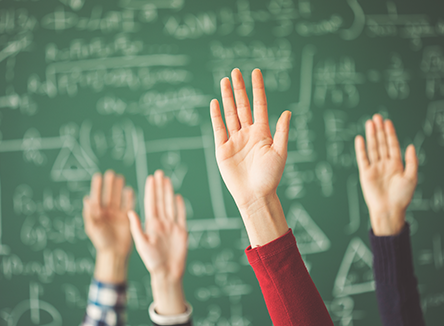 students with hands raised